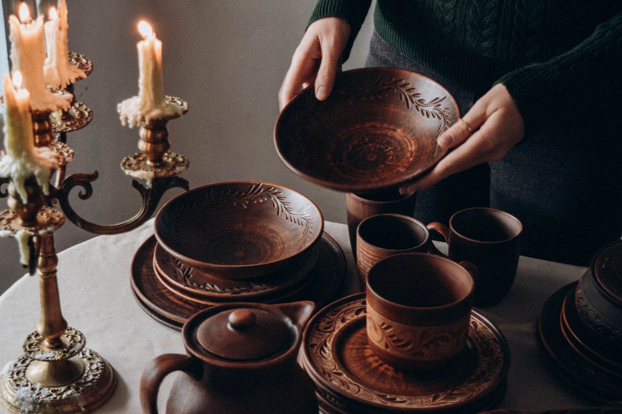 about-bg Warm-toned pottery and candlesticks create a cozy, traditional table setting ambiance.
